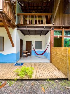 a house with a wooden door and a wooden deck at Barra Quintal - Studio 2 in Barra Grande