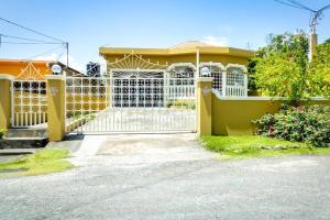 una casa con una puerta blanca y una valla en Cozy Locale Pearl en Port Antonio