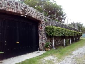 ein Backsteingebäude mit einer schwarzen Garagentür in der Unterkunft Quinta Lachaud in Chiconcuac