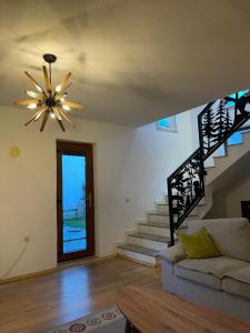 a living room with a ceiling fan and stairs at Villa Alpina Brezovice in Brezovicë