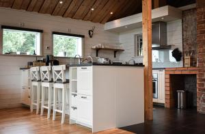 a kitchen with white cabinets and a fireplace at Sjönära boende med tennis- och fotbollsplan in Flen