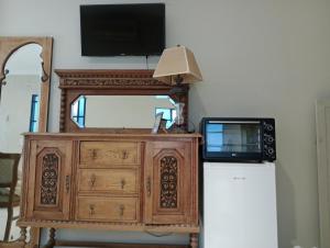 een televisie en een dressoir met een magnetron en een dressoir met een koelkast bij La rue de Rox in Corrientes