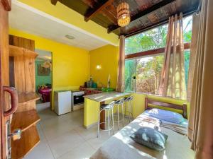 - une cuisine aux murs jaunes et un lit dans une chambre dans l'établissement Barra Quintal Studio 3, à Barra Grande
