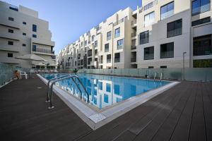 a swimming pool in front of some apartment buildings at Lovely New 1 bed Apt - Mirdif Hills Avenue in Dubai