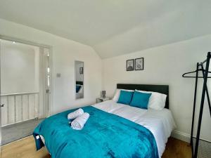a bedroom with a large bed with blue sheets at Contractor Leisure Stay in Romford - Free Parking in Havering atte Bower