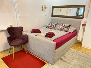 - un lit avec une chaise dans une chambre dans l'établissement Inter Apartment Vienna-Nähe Schönbrunn Palace, à Vienne