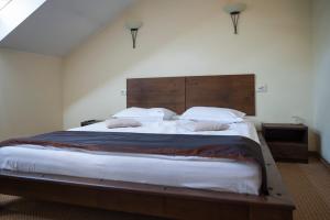 a bedroom with a large bed with a wooden headboard at Pensiunea Diva in Cacica