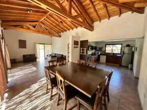 una gran sala de estar con mesa de madera y sillas. en Casa Víctor en Luján de Cuyo