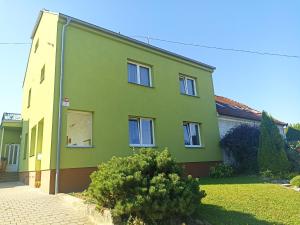 a green house with a tree in front of it at Apartmán Rose in Ostopovice