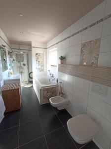 a bathroom with a toilet and a tub and a sink at Apartmán Rose in Ostopovice