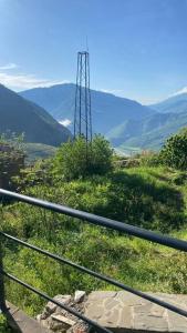 een metalen toren op een heuvel met bergen op de achtergrond bij Vila Hoxha, Mezhgoran 