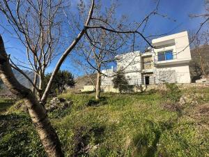 a white house on top of a hill with trees at Vila Hoxha, Mezhgoran 