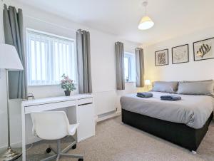 Guest Rooms Near City Centre & Anfield Free Parki في ليفربول: غرفة نوم بسرير ومكتب وكرسي