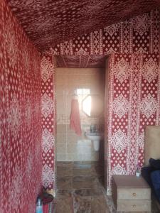 a bathroom with red and white walls and a sink at Wadirum winter in Wadi Rum