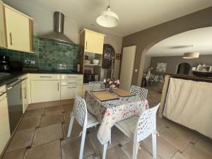 a kitchen with a table and chairs in a kitchen at Maison de vacances avec piscine in Chancelade