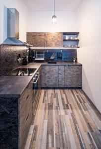 a kitchen with wooden cabinets and a wooden floor at Artistic Urban Retreat Olomouc in Olomouc