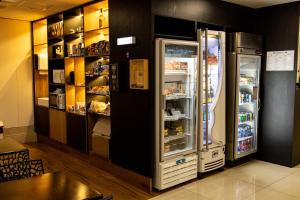 a refrigerator with its door open in a restaurant at Nobile Inn Pampulha in Belo Horizonte