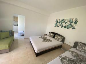 a bedroom with a bed and a couch in it at Apartments Vila Sara M in Ulcinj