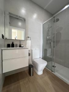 a white bathroom with a toilet and a shower at Urban Oasis La Palma in Santa Cruz de la Palma