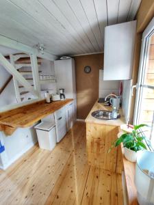 une cuisine avec des armoires blanches et un plancher en bois dans l'établissement Ferienhaus Hans, à Ballenstedt 12 autres photos
