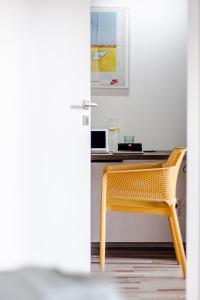 a yellow chair in a room with a desk at Artistic Urban Retreat Olomouc in Olomouc
