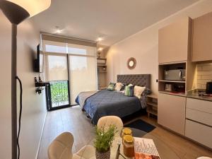 een kleine slaapkamer met een bed en een keuken bij LOFT 31 Villa Alemana BEEHOUSE in Villa Alemana