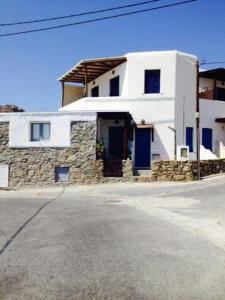 ein weißes Haus mit blauen Türen auf einer Straße in der Unterkunft Mykonian beauty(beach spot) in Platis Gialos