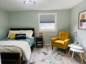 1 dormitorio con 1 cama y 1 silla amarilla en 1970's Inspired Vacation Home 
