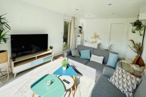 un soggiorno con divano e TV di KosyHouse - Un petit coin de paradis-SPA & Massage a Cauffry