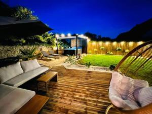 un cortile con una terrazza in legno arredata e una recinzione di KosyHouse - Un petit coin de paradis-SPA & Massage a Cauffry