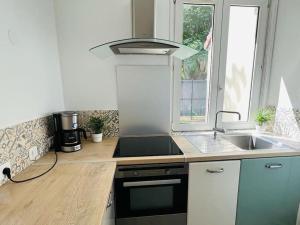 a kitchen with a sink and a stove at KosyHouse - Un petit coin de paradis-SPA & Massage in Cauffry