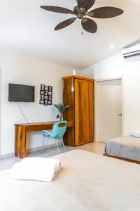 サンタ・テレサにあるBanana Beach Bungalowsのベッドと机と椅子のある寝室