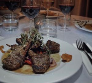 un plato de comida en una mesa con copas de vino en Mellanbrons B&B en Åmål