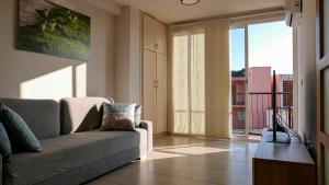 a living room with a couch and a large window at Belair Lloret Sun & Beach in Lloret de Mar