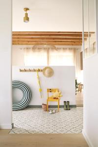 un salon avec une chaise jaune et un mur blanc dans l'établissement Chambres dans maison familiale à Plougastel Dalouas, à 20 minutes de Brest, à Plougastel-Daoulas