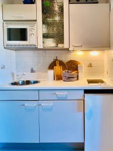 eine Küche mit einer Spüle und einer Mikrowelle in der Unterkunft Ferienwohnung Meernähe in Fehmarn