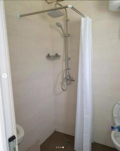 a bathroom with a shower with a curtain and a toilet at lux apartmani Porte Nouva in Sutomore