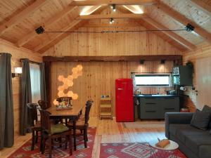 a living room with a table and a red refrigerator at Nica Wood in Sremska Kamenica