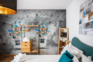1 dormitorio con un mural de mariposas en la pared en La Casa nel Parco luxury b&b, en San Lazzaro di Savena
