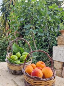 two baskets of fruit sitting on a table at Masseria Vivi il Salento in Santa Caterina di Nardò