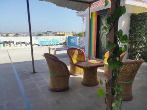 eine Terrasse mit Stühlen, einem Tisch und einem Sonnenschirm in der Unterkunft Nomadic Hostel in Udaipur