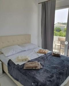 a bedroom with a large bed with two towels on it at lux apartmani Porte Nouva in Sutomore