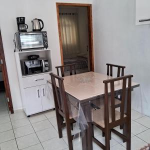 a kitchen with a table with chairs and a microwave at AP número 3 in Governador Celso Ramos