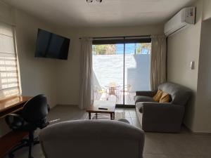 a living room with two couches and a television at Excepcional apartamento, con patio cochera y parrilla en el centro in La Cieneguita