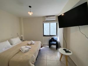 ein Schlafzimmer mit einem Bett und einem Stuhl darin in der Unterkunft Excepcional apartamento, con patio cochera y parrilla en el centro in La Cieneguita