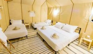 um quarto com duas camas numa tenda em Maria Sahara Camp em Merzouga