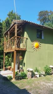 a house with a balcony with a sun on it at Chalé Encantadas Eco Ilha Preserve in Ilha do Mel