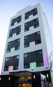 LIC Plaza Hotel في كوينز: مبنى أبيض طويل مع الكثير من النوافذ