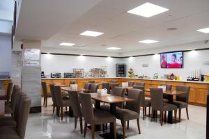 a restaurant with tables and chairs and a counter at LIC Plaza Hotel in Queens