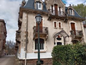 un bâtiment avec un lampadaire devant lui dans l'établissement Pounette, appartement 2 chambres souplex villa Centre Thermes, à Luxeuil-les-Bains